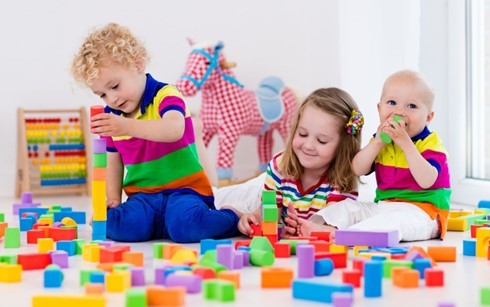 Young children playing with coloured blocks