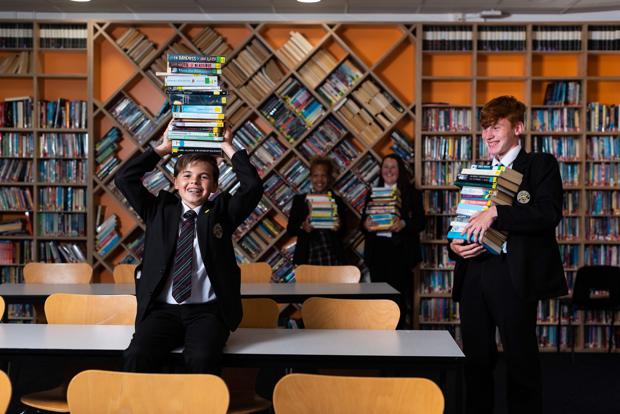 Students holding books in the library